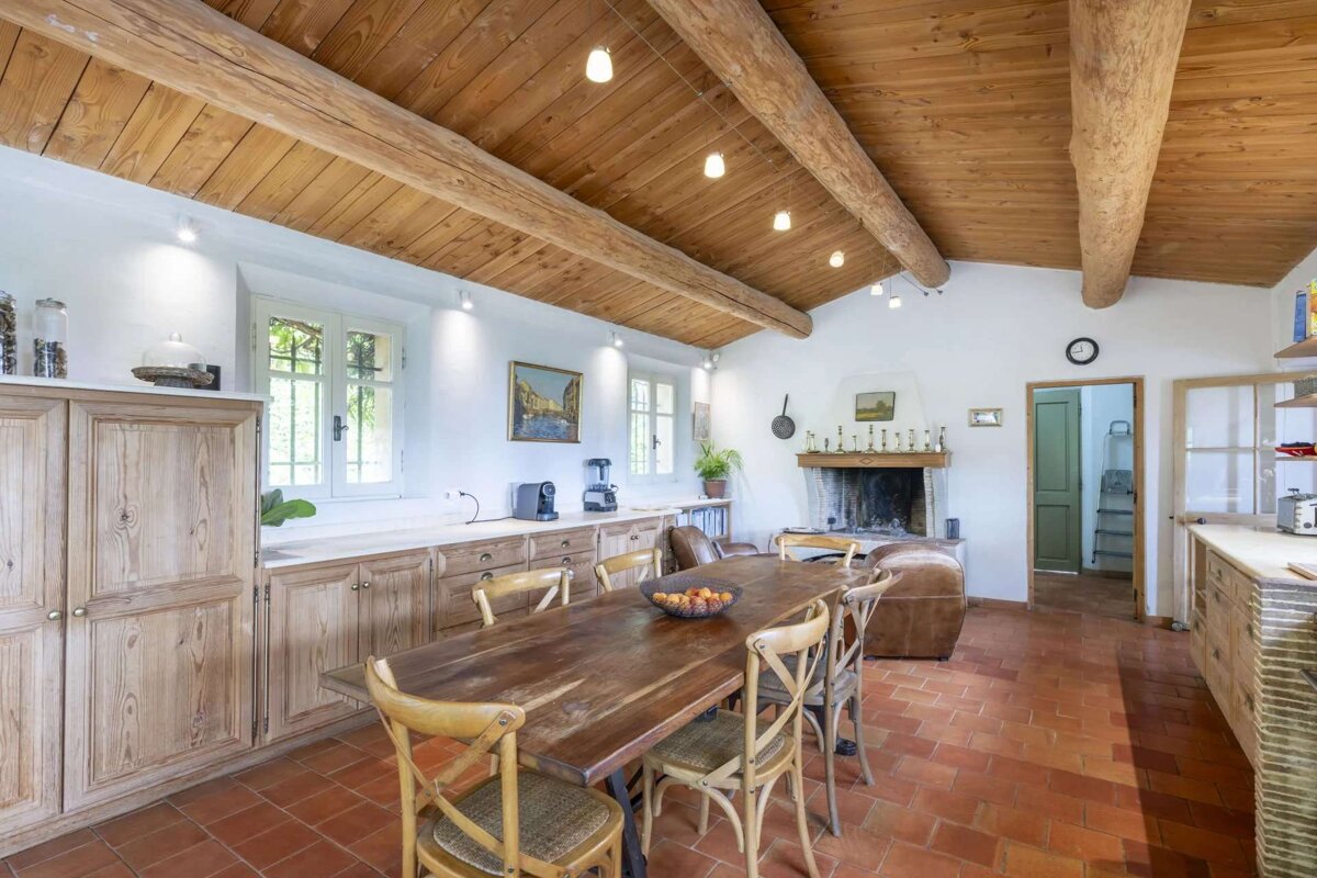 A kitchen with a wooden table and chairs and a fireplace