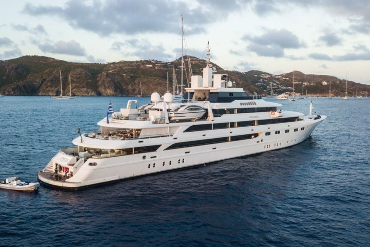 A large white yacht is floating in the ocean