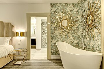 A bathroom with a bathtub and mirrors on the wall