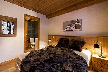 A bedroom with a bed and a mirror on the wall