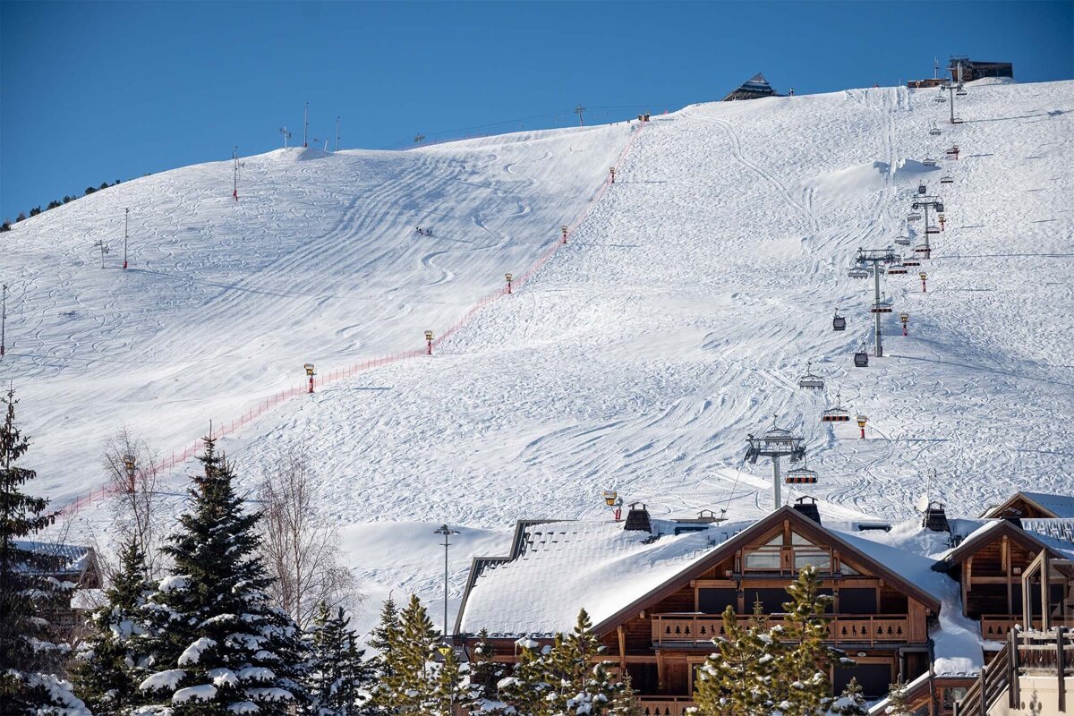 A ski lift is going up a snowy mountain