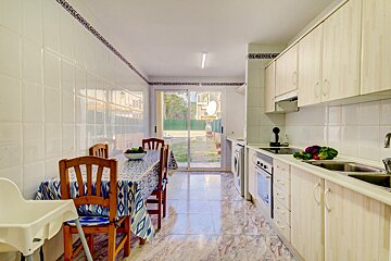 A kitchen with a table and chairs and a sliding glass door
