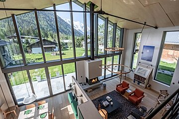 A living room with a fireplace and mountains in the background