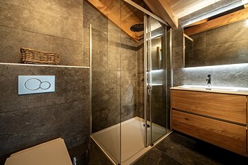 A bathroom with a walk in shower and a sink