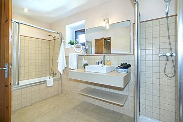 A bathroom with a sink a mirror and a shower