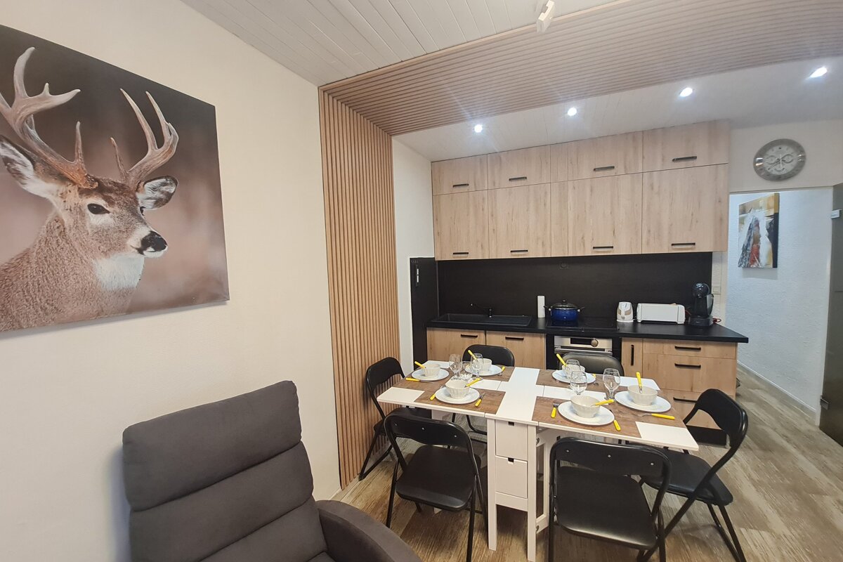 A kitchen with a table and chairs and a picture of a deer on the wall