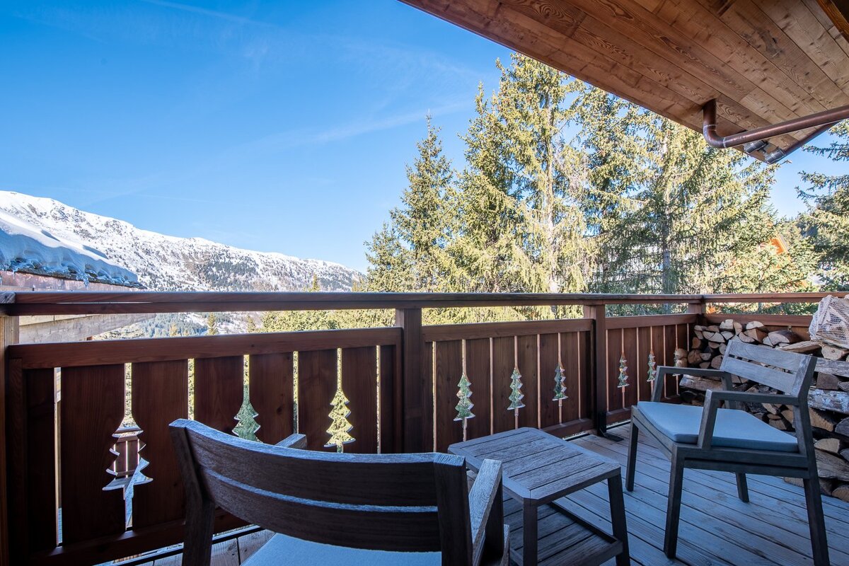 A balcony with a wooden railing with trees carved into it
