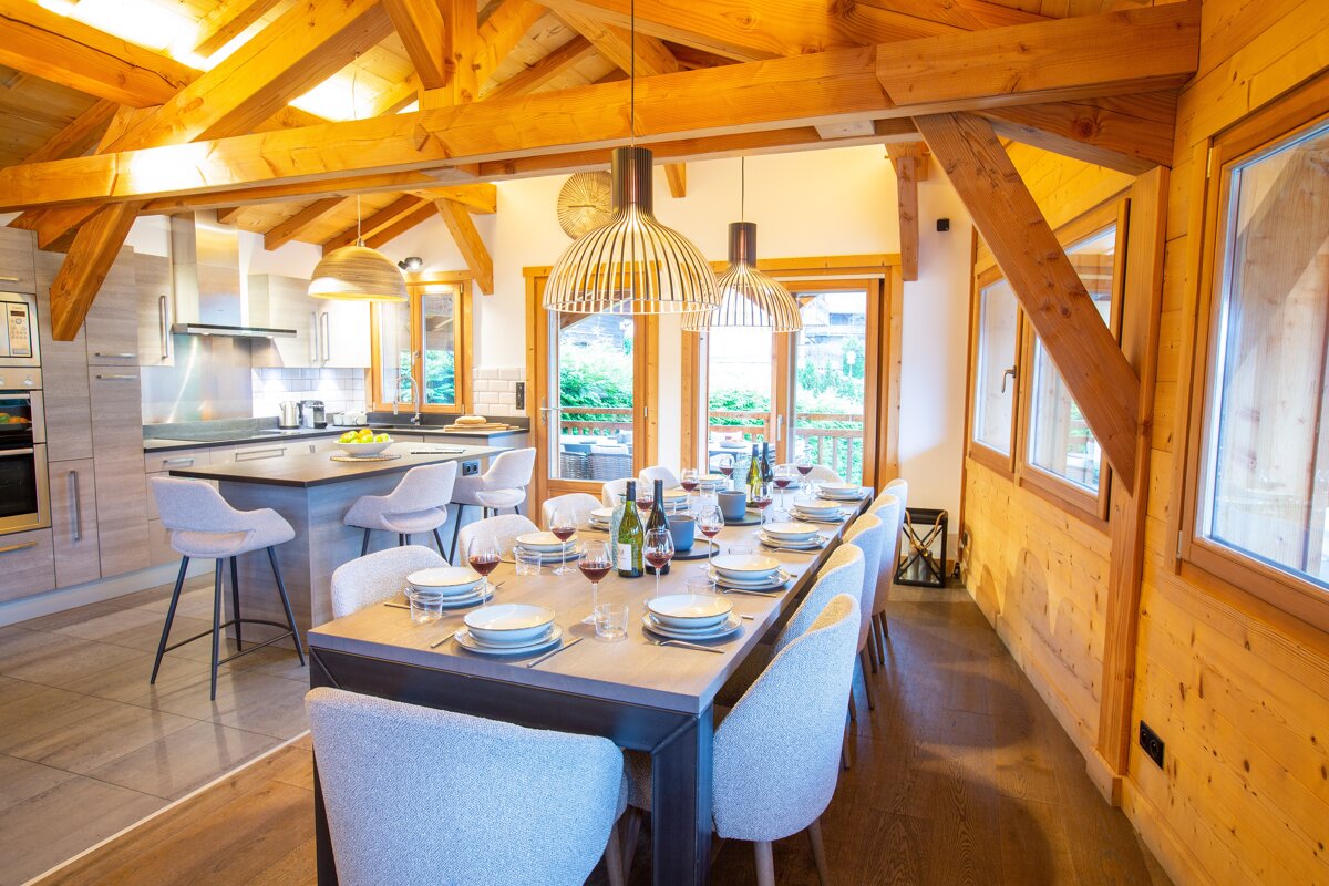 A dining room table with plates and wine glasses on it