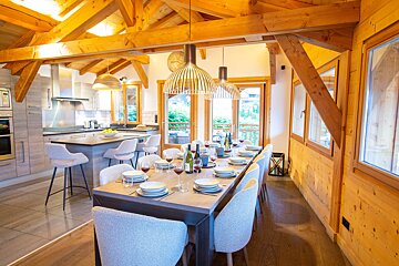A dining room table with plates and wine glasses on it