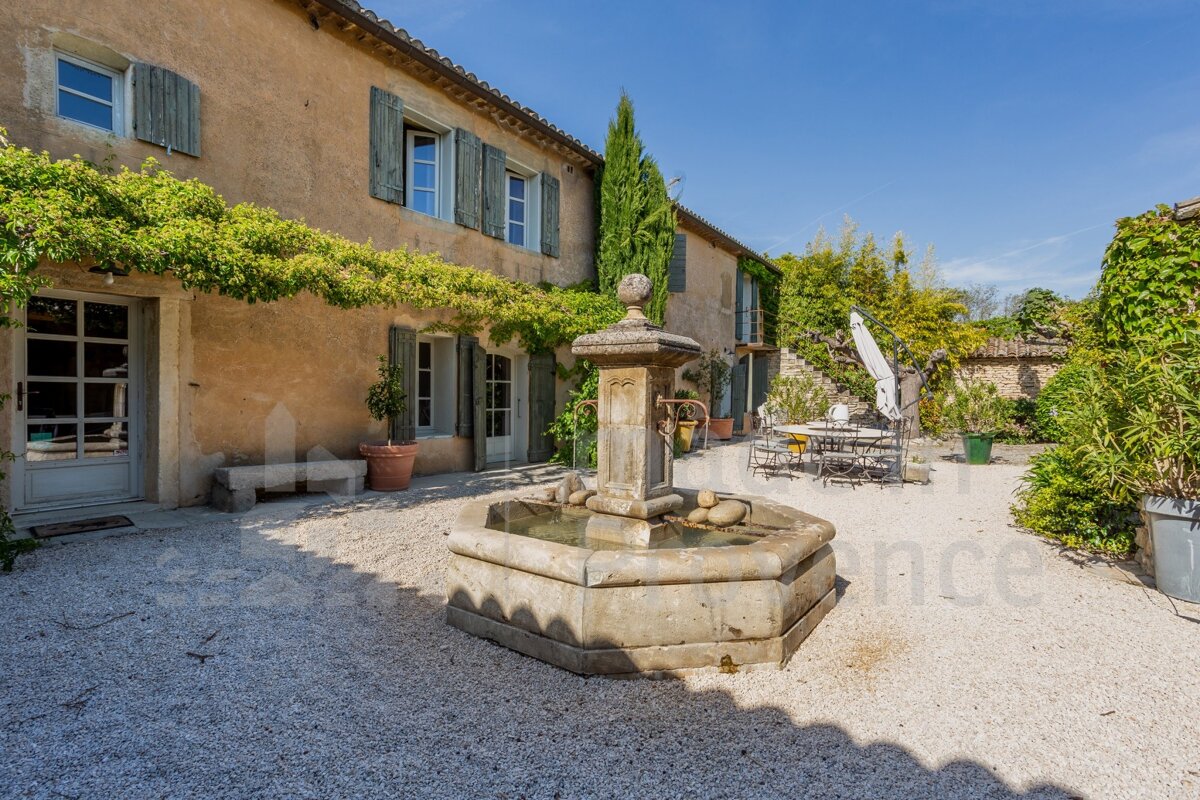 A stone fountain in front of a building with the word france on the bottom