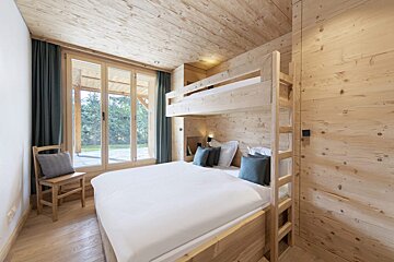A bedroom with a bunk bed and a chair