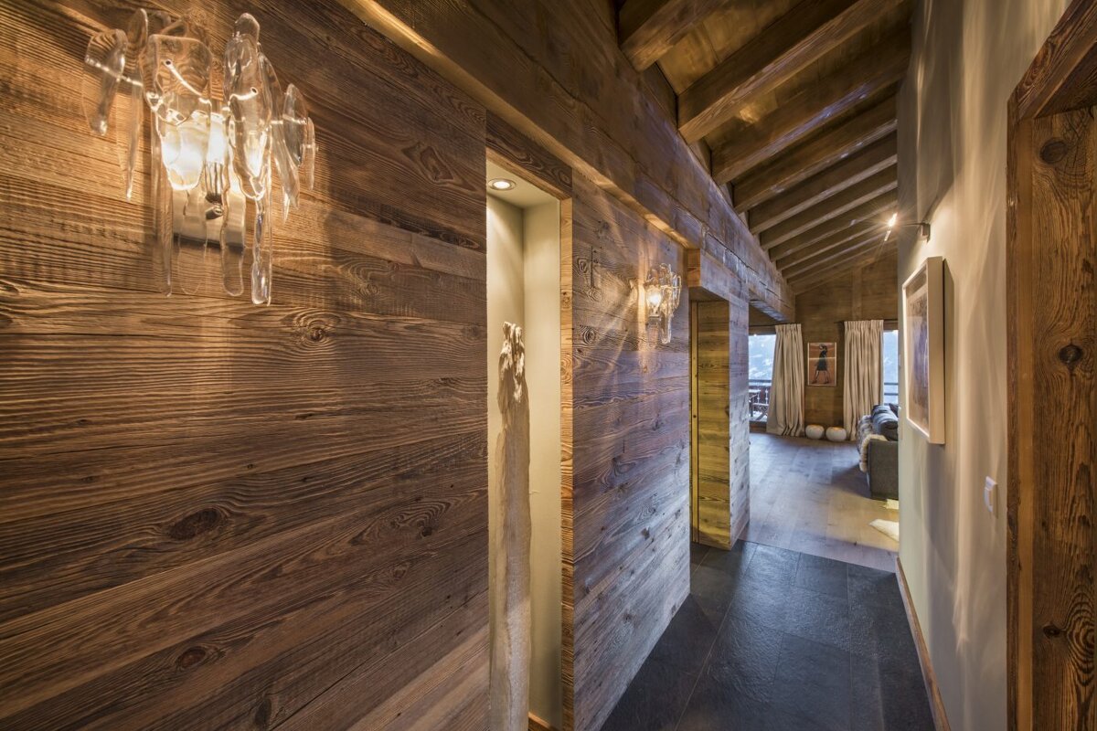 A wooden hallway with a few lights on the wall