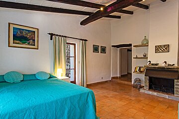 A bedroom with a blue bed and a fireplace