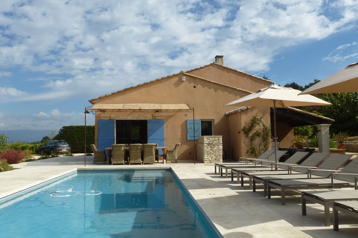 A house with a swimming pool in front of it
