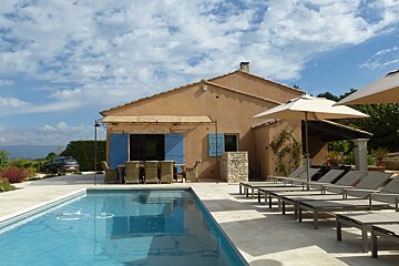 A house with a swimming pool in front of it