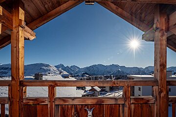 The sun is shining brightly over the snowy mountains