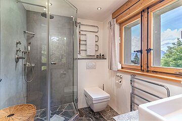 A bathroom with a toilet and a walk in shower