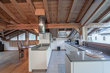 A kitchen with wooden beams and white cabinets