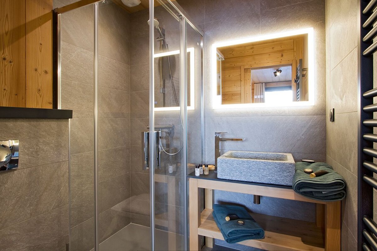 A bathroom with a walk in shower and a sink
