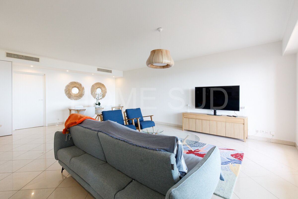 A living room with a couch and a television with the word mesud on the wall
