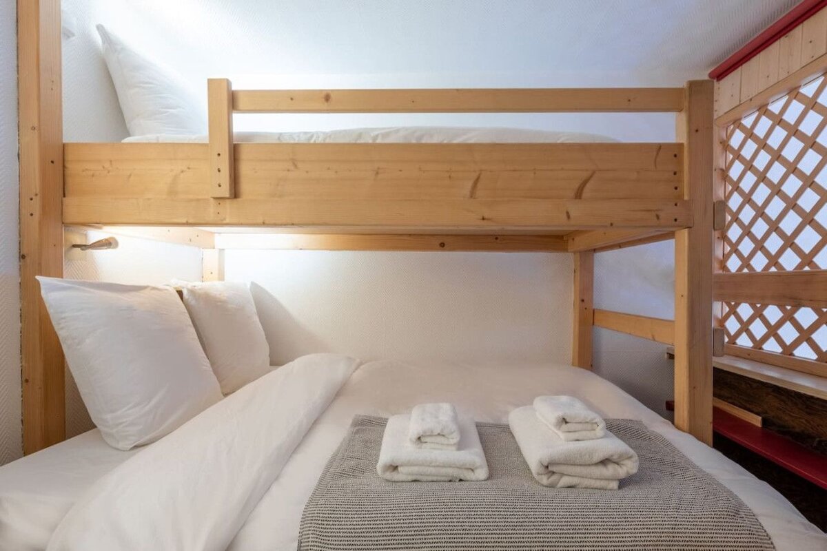 A bunk bed with white sheets and towels on it