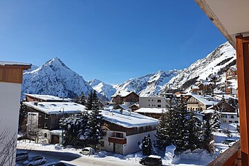 A view of a snowy town with mountains in the background