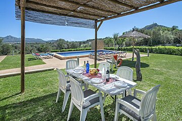 A patio with a table and chairs and a bottle of wine