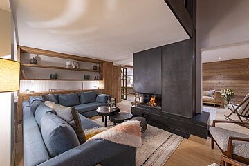 A living room with a blue couch and a fireplace