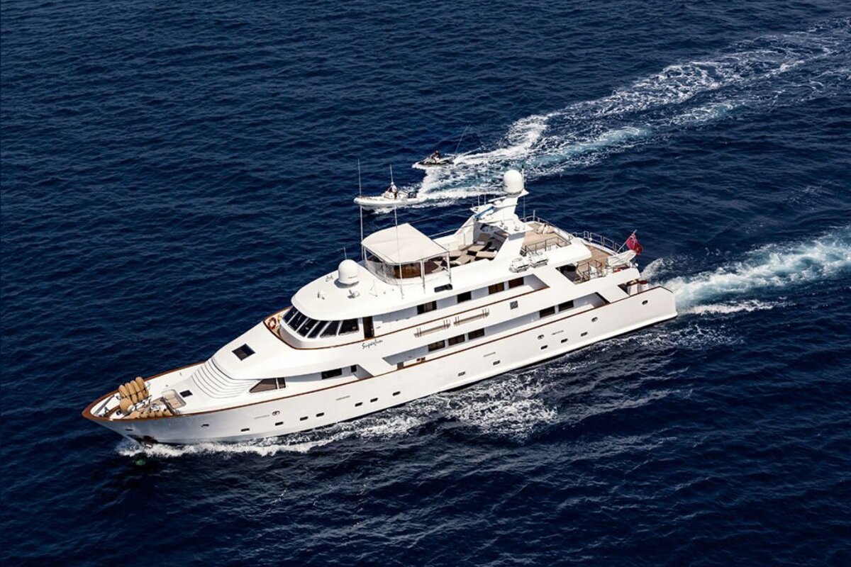 A large white yacht is floating in the ocean