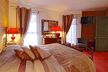 A bedroom with a large bed and two red lamps