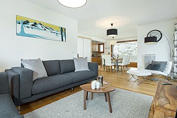 A living room with a couch and a clock on the wall