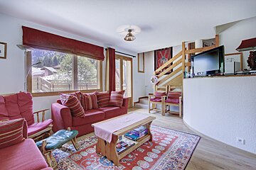 A living room with a red couch and a flat screen tv