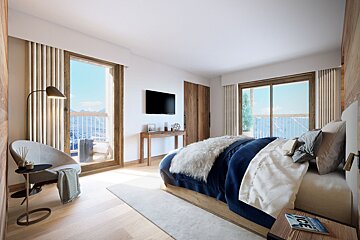 Cozy modern chalet bedroom with a plush bed, reading chair, and large windows offering scenic mountain balcony views.