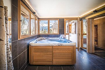 A hot tub in a bathroom with a view of the mountains