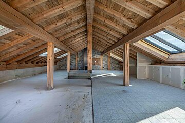 An empty attic with wooden beams and skylights