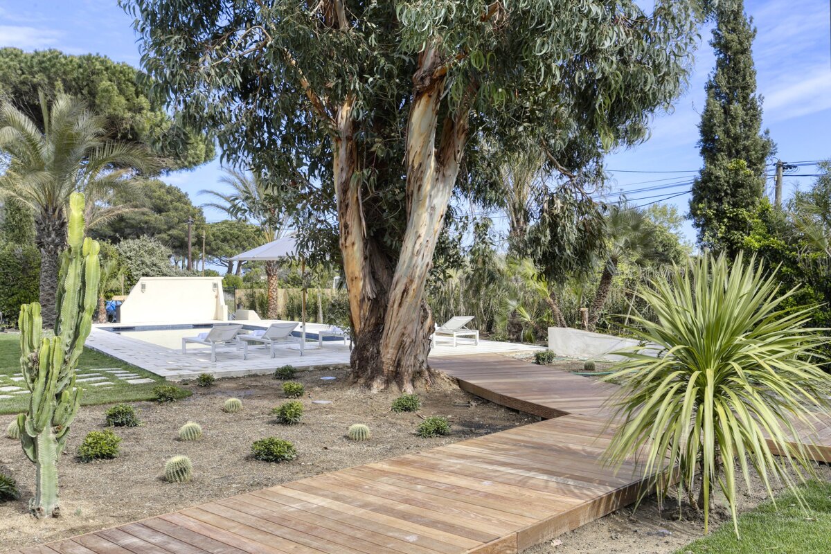 A wooden walkway leads to a swimming pool