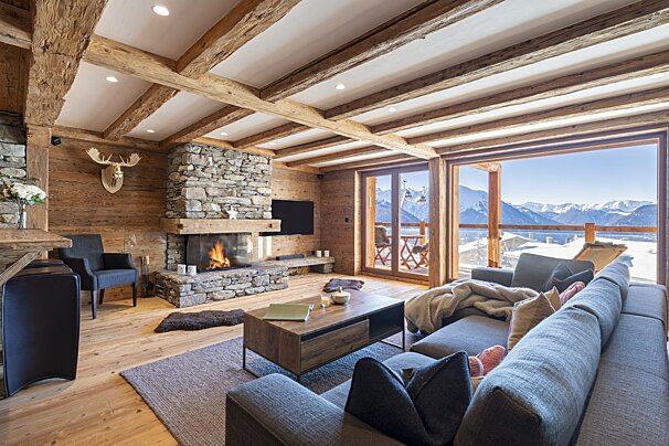 A living room with a fireplace and a view of the mountains