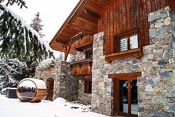 A large stone building with a wooden roof is covered in snow
