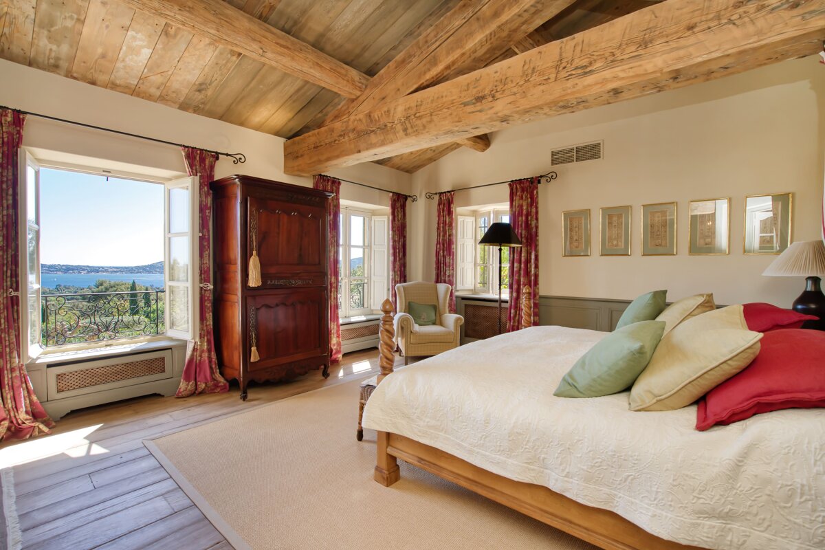 A bedroom with a large bed and a large window