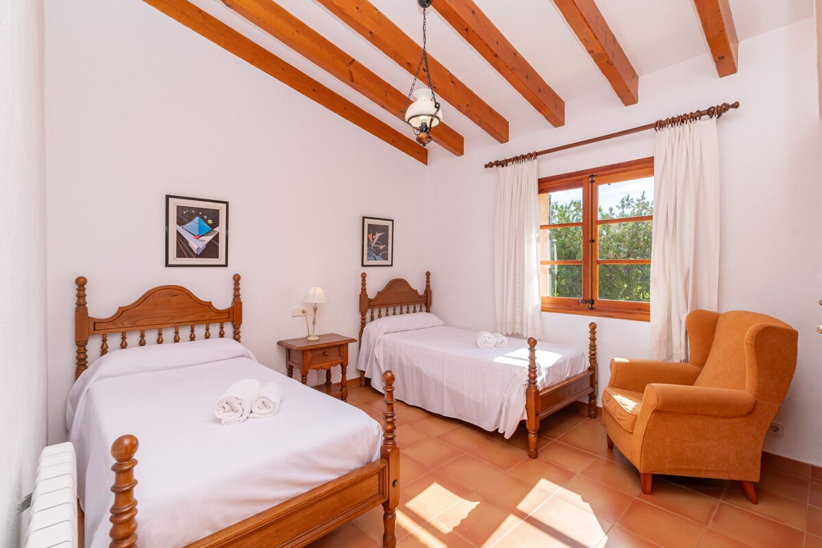 A bedroom with two twin beds and a chair