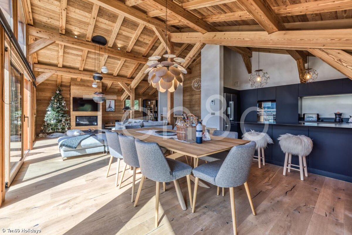 A wooden house with a dining table and chairs