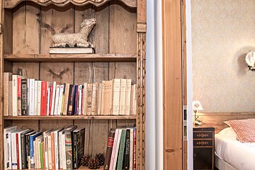 A wooden cabinet in a hallway with a picture on the wall above it
