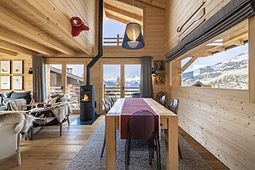 A wooden house with a dining table and chairs