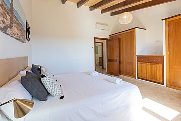 A bedroom with a large bed and wooden cabinets