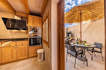 A kitchen with a table and chairs and an umbrella