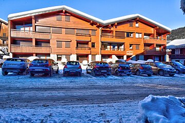 A row of cars are parked in front of a building with a sign that says ' montagne ' on it