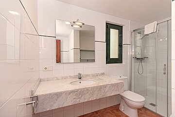 A bathroom with a toilet a sink and a mirror