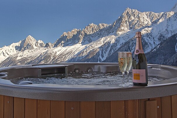 A bottle of veuve clicquot sits in a hot tub
