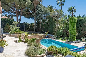 A large swimming pool surrounded by trees and bushes