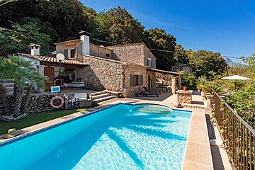 A house with a large swimming pool in front of it